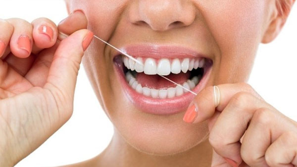 Dùng chỉ tơ nha khoa để lấy sạch mảng bám trên răng